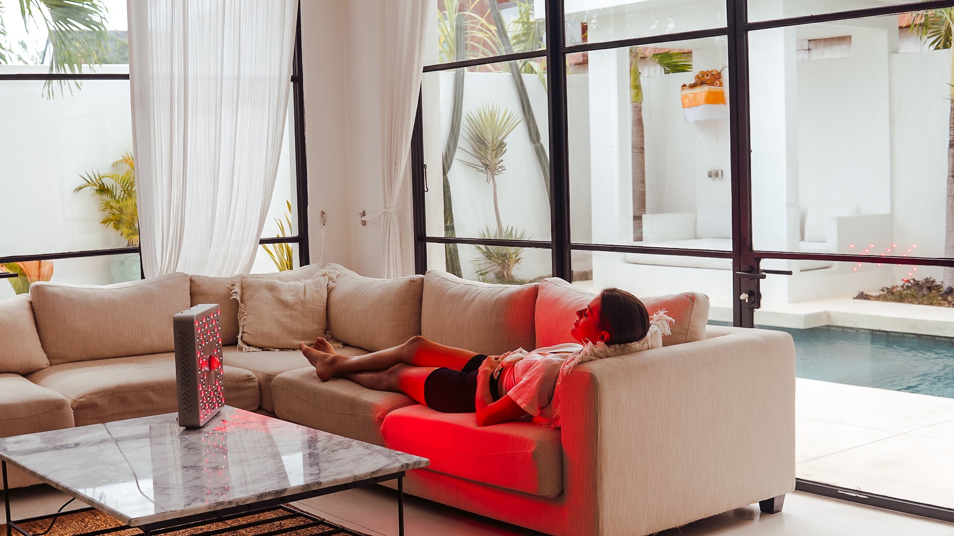 a woman in the drawing room lying on her sofa and using EMR-TEK firedragon